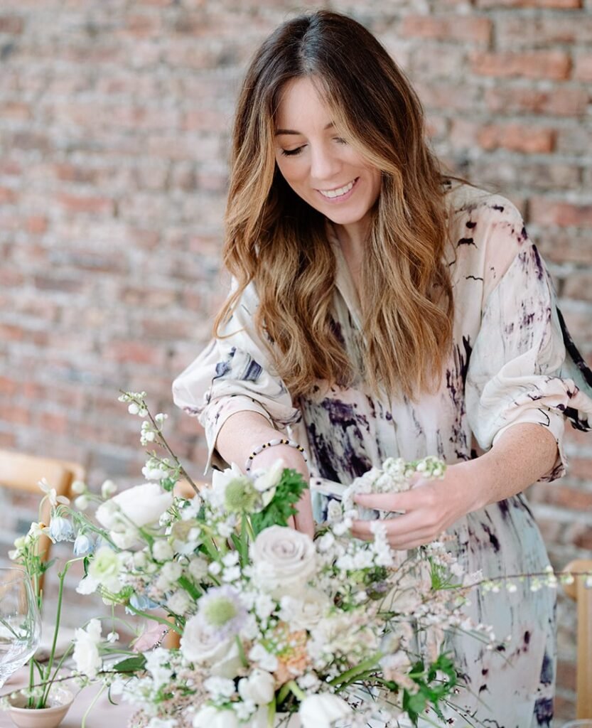 Founder of Winter and the Willows, Rhian, putting the finishing touches to floral table centre-pieces